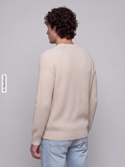 Mężczyzna model nosi sweter z bawełny Regular Fit Pullover aus reiner Baumwolle model 'BRAUN' od Selected w kolorze jasnobeżowym, struktura prążkowana, tło szare, kontekst: sweter męski od Selected, widok całej sylwetki tył, KI-modifiziertes Bild