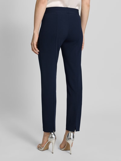 Frauenmodel trägt Hose mit Bügelfalten von Vera Mont in Dunkelblau, Material-Mix mit Stretch-Anteil, elastischer Bund, Ganzkörperansicht Rückansicht.