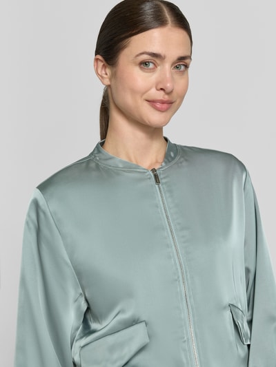 Vrouwenmodel draagt Blouson met Pattentaschen und Reißverschluss van Zero in lichtgroen materiaalmix met stretch, straight fit, opstaande kraag, ritssluiting en zij-klepzakken. Nahaufnahme bovenlichaam.