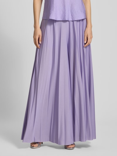 Frauenmodel trägt Wide Fit Stoffhose in Falten-Optik Modell 'Samantha' von GUIDO MARIA KRETSCHMER WOMAN, fliederfarben, Nahaufnahme Oberkörper, Elastikbund, Bundweite 36 cm, Innenbeinlänge 75 cm, glatte Textur.