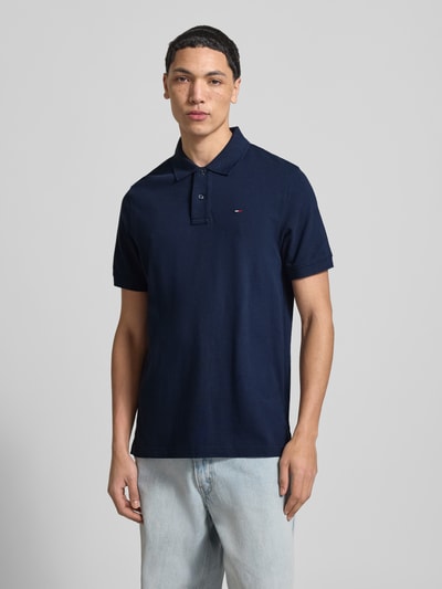Męski model nosi Regular Fit Poloshirt aus reiner Baumwolle von Tommy Jeans, efekt: jednolity kolor, wyhaftowane logo, kołnierzyk polo, krótki rękaw, wykończenie: z bocznymi rozcięciami, wykończenie materiału: pika, bawełna, całkowity widok z przodu