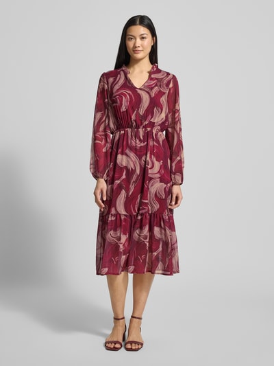 Modelka nosi Midikleid mit V-Ausschnitt Modell 'Za44raa' od ZABAIONE, bordowy wzór, lekko rozkloszowany fason, długość midi, widok z przodu.