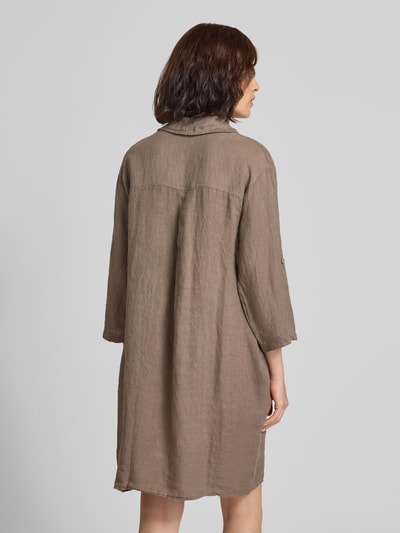 Frauenmodel trägt knielanges Leinenkleid mit Hemdblusenkragen Modell 'Li44ana' von ZABAIONE, lockerer Schnitt, Rückansicht, braune Naturtextur.