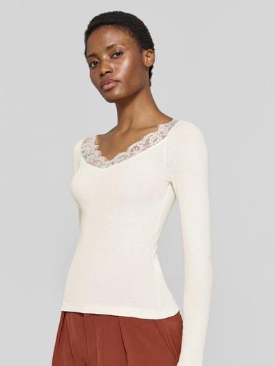 Frauenmodel trägt Slim Fit Shirt aus reiner Baumwolle von Rich & Royal, cremefarben, Spitzen-Besatz, Langarm, Nahaufnahme Oberkörper.