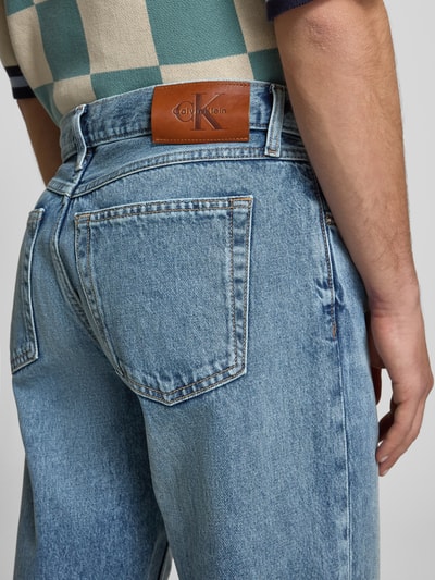 Männermodel trägt Regular Fit Jeans aus reiner Baumwolle von Calvin Klein Jeans, Denim-Optik, Label Patch, 5-Pocket, Ganzkörperansicht Rückansicht.