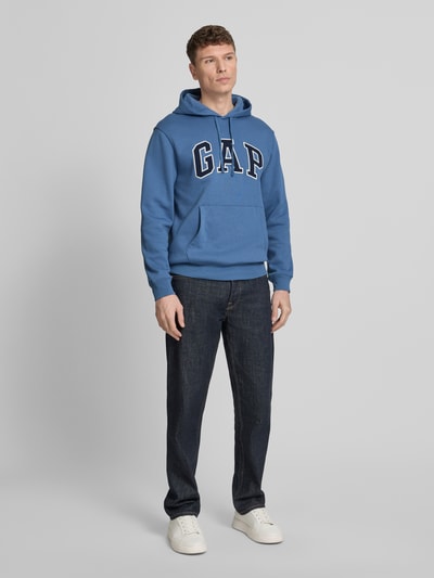 Männermodel trägt Hoodie mit Kängurutasche von GAP in blau, lockere fit, katoenmix, label-stitching, ribboorden, Ganzkörperansicht von vorne