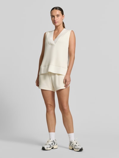 Vrouwenmodel draagt top uit mix van viscose en elastaan in tricotlook Model 'Freida' van VARLEY, v-hals, ribboorden, los model, ruglengte maat S 40 cm, vooraanzicht full-body