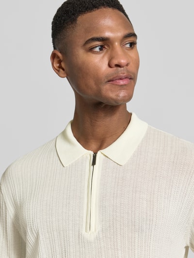 Männermodel trägt Body Fit Poloshirt mit kurzem Reißverschluss von Emporio Armani in Creme, reine Baumwolle, Nahaufnahme Oberkörper.