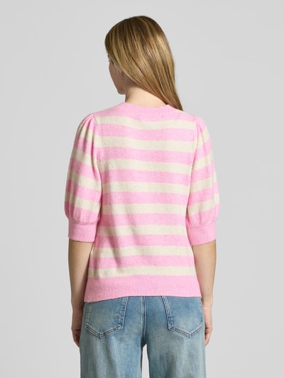 Frauenmodel trägt Regular Fit Strickpullover mit Crew Neck Modell 'DOFFY' von Vero Moda in Optik:Unifarben, Strickoptik, Label-Stitching-Applikation, Rundhals, 1/2-Arm, gerippte Abschlüsse, Materialverarbeitung: Strick, rosa-weiß gestreift, Ganzkörperansicht Rückansicht.