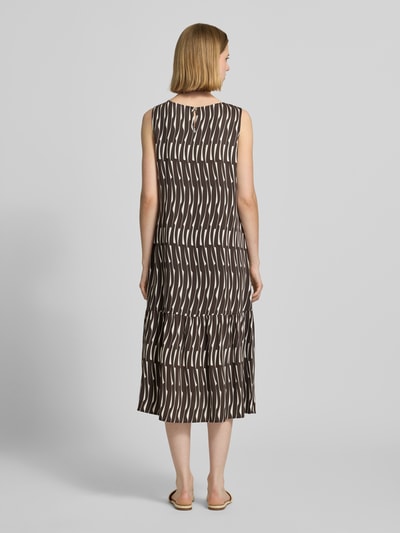 Frauenmodel trägt Midikleid mit rückseitigem Schlüsselloch-Ausschnitt von OPUS, Reine Viskose, Gerader-Schnitt, Modell 'Wicy bamboo', Rückenlänge 115 cm, Brustweite 49 cm, braunes und weißes Muster, fließende Textur, Ganzkörperansicht Rückansicht.
