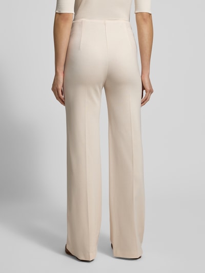 Frauenmodel trägt Stoffhose aus Viskose-Mix mit Bügelfalten von Marc Cain in Beige, elastischer Bund, Reißverschlusstaschen, Ganzkörperansicht Rückansicht.