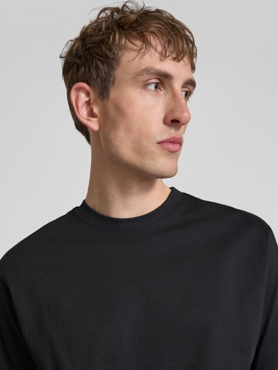 Männermodel trägt Relaxed Fit T-Shirt aus reiner Baumwolle Modell 'FRED LIFE' von Only & Sons, unifarben, Nahaufnahme Oberkörper.