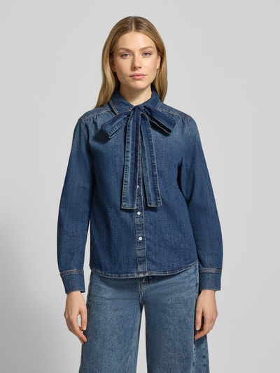Vrouwenmodel draagt Hemdbluse in Denim-Optik van Oui, blauwe katoen-elastaanmix, losse pasvorm, strikdetail, borstzak, denimtextuur, voorkant volledig zichtbaar, geheel vooraanzicht.