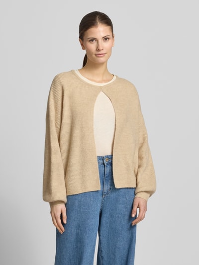 Frauenmodel trägt Cardigan mit Knopfverschluss Modell 'Deriana' von OPUS in beigefarbenem Woll-Mix, langer Ärmel, Ganzkörperansicht von vorne.