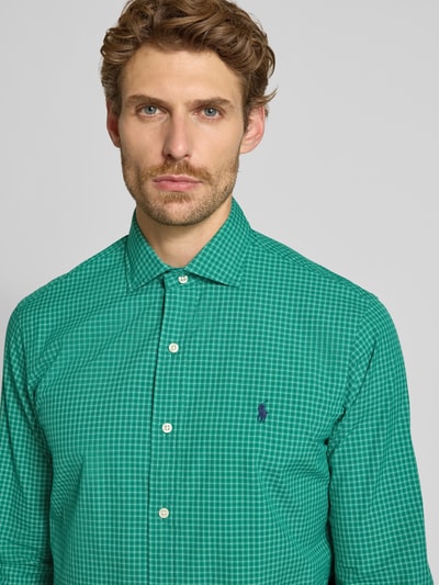 Männermodel trägt Custom Fit Freizeithemd aus reiner Baumwolle von Polo Ralph Lauren in Grün mit Karomuster und weißen Knöpfen, Nahaufnahme Oberkörper.