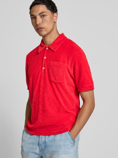 Männermodel trägt Regular Fit Poloshirt aus Baumwoll-Mix von Closed in kräftigem Rot mit Polokragen, Brusttasche, Nicki; Nahaufnahme Oberkörper.