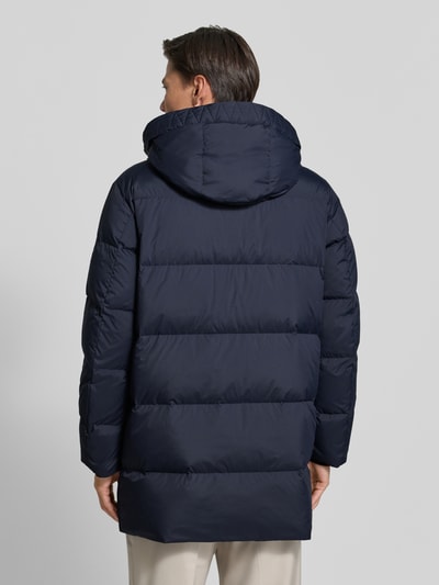 Männermodel trägt Regular Fit Daunenjacke mit Kapuze von Marc O'Polo, dunkelblau, uni, zweiwege-reißverschluss, Rückansicht Ganzkörperansicht.