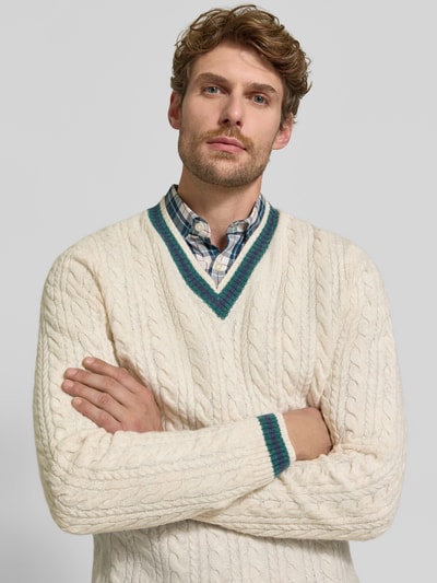 Männermodel trägt Strickpullover mit Woll-Anteil von MCNEAL in Creme, Zopfmuster, gerippte Abschlüsse, Nahaufnahme Oberkörper, Woll-Mix.