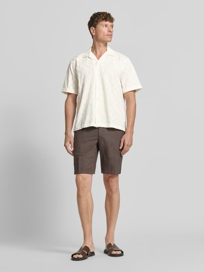 Männermodel trägt Relaxed Fit Freizeithemd aus reiner Baumwolle Modell 'HAMISH' von Selected Homme, helles Creme, leichte Struktur, Herren, Ganzkörperansicht von vorne.