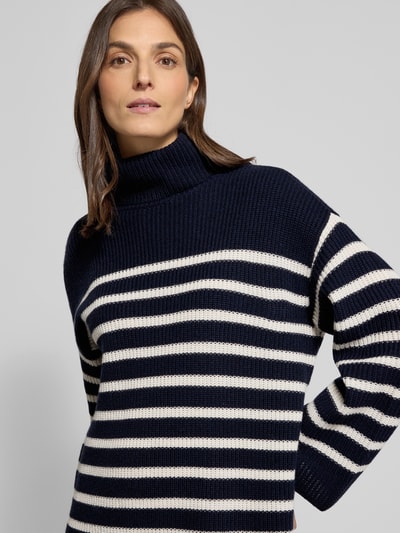 Frauenmodel trägt Mini-Strickkleid aus Woll-Kaschmir-Mix Modell 'AREENA' von Lauren Ralph Lauren in dunkelblau mit weißen Querstreifen, Oversized, Rollkragen, gerippte Abschlüsse, Kontext: Damen Strickkleid in Oversized-Fit, Minilänge, Rückenlänge 83 cm, Ärmellänge 67 cm, Nahaufnahme Oberkörper.