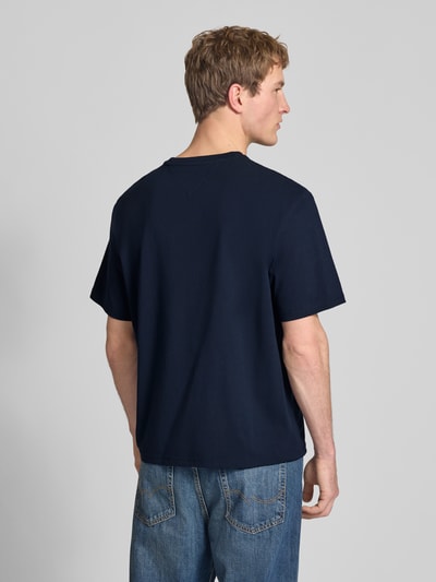Männermodel trägt Regular Fit T-Shirt aus reiner Baumwolle von Tommy Jeans in Optik: Unifarben, Ganzkörperansicht Rückansicht.