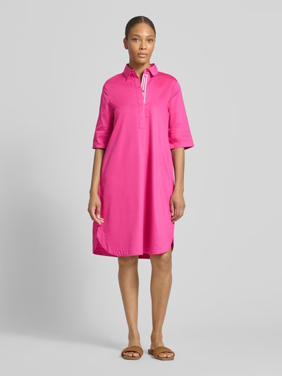 Frauenmodel trägt knielanges Hemdblusenkleid mit Eingrifftaschen von Christian Berg Woman in Pink, reine Baumwolle, Ganzkörperansicht von vorne.