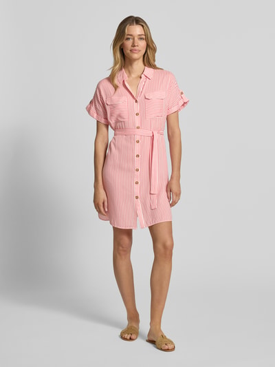 Vrouwenmodel draagt vrijetijdsjurk van Vero Moda, model 'BUMPY', look: effen, pasvorm: vloeiend, minilengte, V-hals, achterpas, knoopsluiting, korte mouw, materiaalverwerking: popeline, materiaal: zuiver viscose, lichte stoffenstructuur, pastelroze en wit, vooraanzicht hele lichaam.