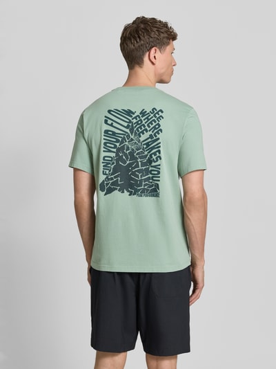 Männermodel trägt T-Shirt mit Label-Print und Rundhalsausschnitt von PEAK PERFORMANCE in Mint, Reine Baumwolle, Regular-Fit, Ganzkörperansicht Rückansicht