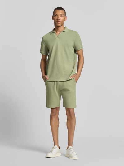 Männermodel trägt Regular Fit Shorts mit Tunnelzug von MCNEAL aus Baumwoll-Mix mit Stretch-Anteil, farblich hellgrün, Eingrifftaschen, Gesäßtasche, Ganzkörperansicht von vorne.