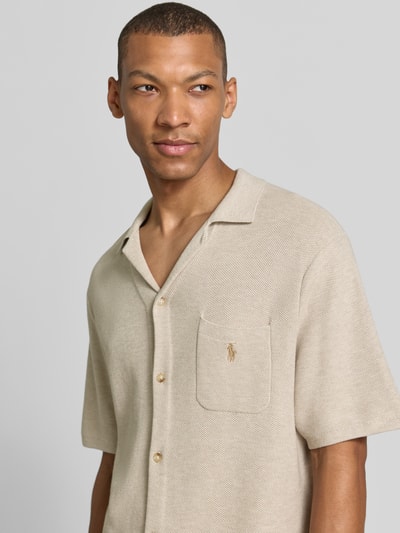 Männermodel trägt Regular Fit Poloshirt aus reiner Baumwolle von Polo Ralph Lauren in Beige mit Kurzarm, dezenter Struktur, Nahaufnahme Oberkörper.