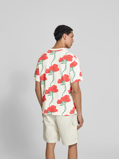 Männermodel trägt T-Shirt mit floralem Allover-Print von Kenzo aus reiner Baumwolle, Regular Fit, weiß-rot-grün, Ganzkörperansicht Rückansicht.