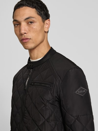 Männermodel trägt Regular Fit Jacke in Stepp-Optik von Replay, schwarze Farbe, dezente Steppnähte, Nahaufnahme Oberkörper.