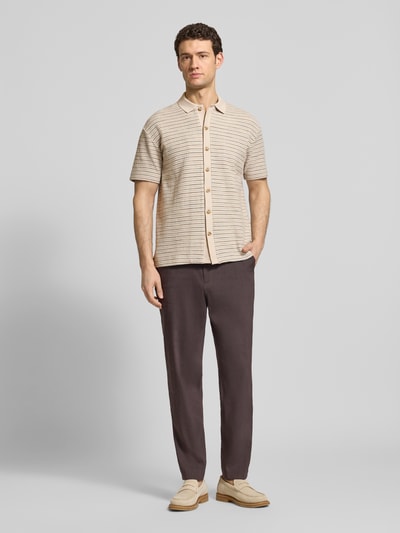 Männermodel trägt Relaxed Fit Poloshirt aus reiner Baumwolle von Marc O’Polo, unifarben, gestreift, Crinkle-Optik, Ganzkörperansicht von vorne.