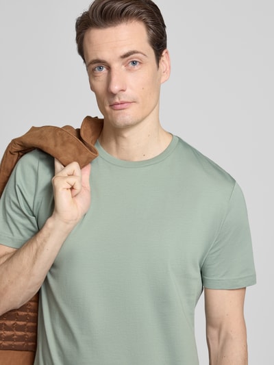 Männermodel trägt T-Shirt mit Rundhalsausschnitt von Christian Berg Men in Hellgrün, reine Baumwolle, Regular Fit, Nahaufnahme Oberkörper.