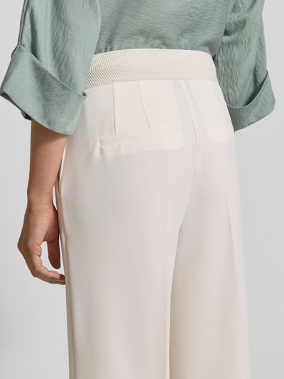 Männermodel trägt Wide Fit Stoffhose mit Bügelfalten Modell 'Juli' von Betty Barclay, elastyczny materiał, szerokość w rozmiarze 36: 35 cm, długość nogawki 64 cm, z tyłu detal, zdjęcie tylna perspektywa