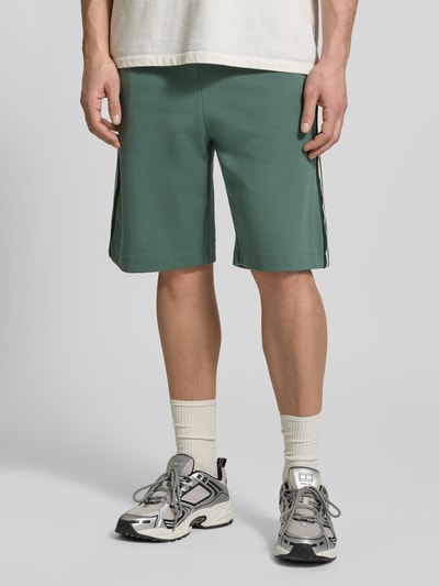 Männermodel trägt Shorts mit elastischem Bund von EA7 Emporio Armani in Grün, Baumwoll-Mix, Regular Fit, Nahaufnahme Oberschenkel, Vorderansicht.
