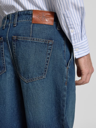 Männermodel trägt Barrel Fit Jeans mit Eingrifftaschen Modell 'BARREL BENSON' von Calvin Klein Jeans aus reiner Baumwolle, Detailaufnahme Rückansicht.