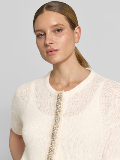 Frauenmodel trägt Strickjacke mit Ziersteinbesatz und 1/2-Arm von Luisa Cerano, cremefarben, Material-Mix mit Alpaka, Nahaufnahme Oberkörper.