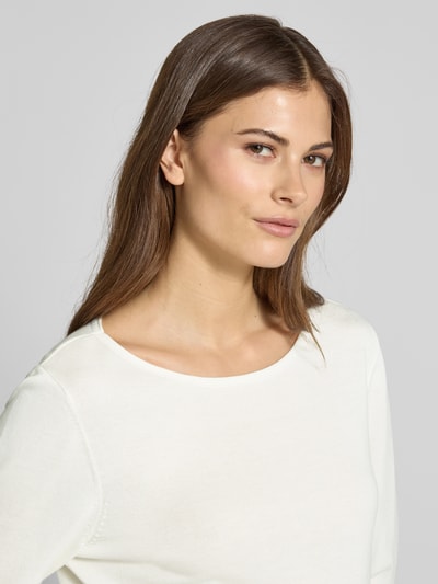 Vrouwenmodel draagt Regular Fit Langarmshirt aus Baumwoll-Viskose-Mix van s.Oliver RED LABEL in effen wit, strickstructuur, ronde hals, rolzoom. Nahaufnahme bovenlichaam.