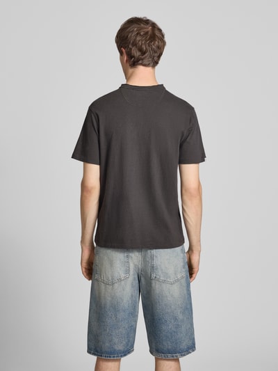 Männermodel trägt Herren T-Shirt mit kurzer Knopfleiste von Superdry, Leinen-Baumwoll-Mix, Regular-Fit, Logo-Stitching, Rückenlänge 62 cm, Ganzkörperansicht Rückansicht.