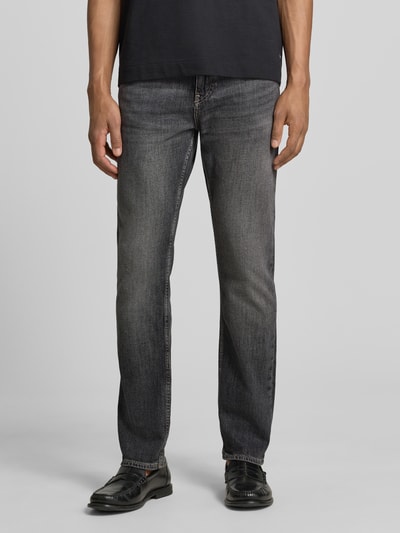 Männermodel trägt Slim Fit Jeans aus Stretch-Denim Modell 'DELAWARE' von BOSS in grauer Denim-Optik, 5-Pocket-Design, Ganzkörperansicht von vorne.