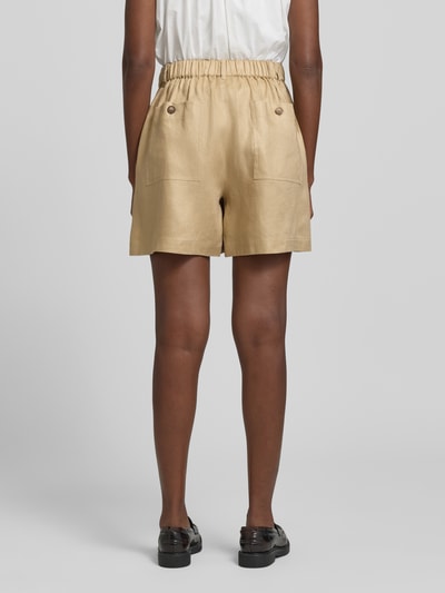 Männermodel trägt Regular Fit Shorts aus reinem Leinen Modell 'IVELETTA' von Weekend Max Mara, kolor beżowy, gładka faktura, widoczne kieszenie, widok całej sylwetki od tyłu.