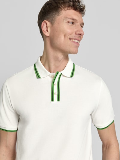 Männermodel trägt Regular Fit Poloshirt mit Kontraststreifen von PAUL SMITH aus Baumwoll-Elasthan-Mix, Nahaufnahme Oberkörper.
