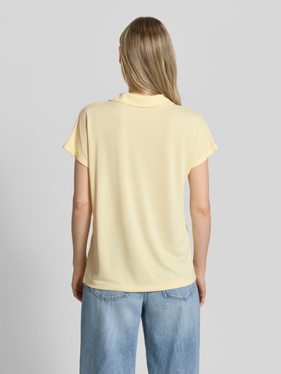 Frauenmodel trägt Regular Fit Poloshirt aus Modal-Mix von Christian Berg Woman in Hellgelb, glatte Textur, Rückenansicht Ganzkörperansicht. Damen Poloshirt, V-Ausschnitt, Ärmel mit Aufschlag, Rückenlänge bei Größe S: 46 cm.