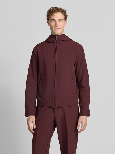 Männermodel trägt Jacke mit Kapuze und Zweiwege-Reißverschluss von Emporio Armani in Burgunderrot, Material-Mix mit Stretch-Anteil, Eingrifftaschen, Regular-Fit, Ganzkörperansicht von vorne. Rückenlänge 66 cm, Schulterbreite 56 cm, Brustweite 58 cm, Ärmellänge 68 cm bei Größe 50.