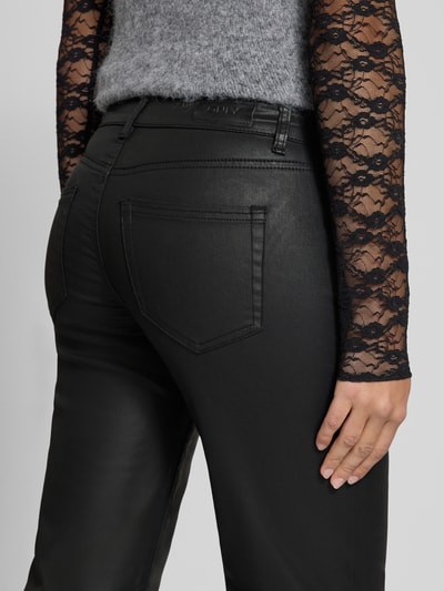 Frauenmodel trägt Mid Waist Lederhose mit matter Optik von ONLY, schwarze Lederoptik, 5-Pocket-Design, Nahaufnahme Rückansicht.