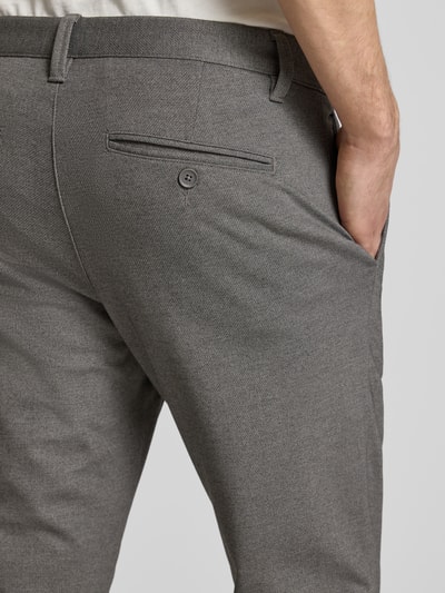 Männermodel trägt Slim Fit Chino aus Viskose-Mix Modell 'MARK' von Only & Sons in Melange-Optik mit Gesäßtaschen, Nahaufnahme Rückansicht.