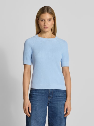 Frauenmodel trägt Regular Fit Strickpullover aus Viskose-Baumwoll-Mix Modell 'ELINNA' von Selected Femme in Hellblau, Strukturmuster, Rundhals, kurzarm, gerippte Abschlüsse, unifarben, Ganzkörperansicht von vorne.