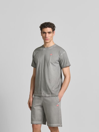 Männermodel trägt Regular Fit T-Shirt aus reiner Baumwolle von Diesel in Grau mit Used-Look, Label-Details, Herren T-Shirt, Ganzkörperansicht von vorne. Rückenlänge bei Größe M: 70 cm.