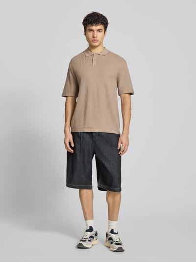 Männermodel trägt Relaxed Fit Poloshirt Modell 'FERDINAND' von Redefined Rebel aus Reine Baumwolle, beige Farbe, Strickshirt, Knopfleiste, Rückenlänge bei Größe M 70 cm, Ganzkörperansicht von vorne.